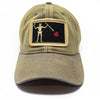 Neutral grey trucker hat with embroidered Blackbeard pirate flag patch on the center and khaki mesh back panels. Patch depicts a natural colored skeleton with horns piercing a red bleeding heart with a spear. 