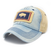 Light blue jean colored trucker hat with khaki mesh panels on the back and navy blue stitching. Ballcap is embroidered with the Wyoming flag. The patch depicts a natural Bison inside of a dark blue rectangle with a red border.